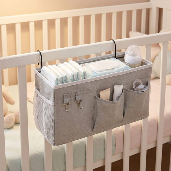 Grey bedside fabric hanging organizer used on baby crib for diaper storage