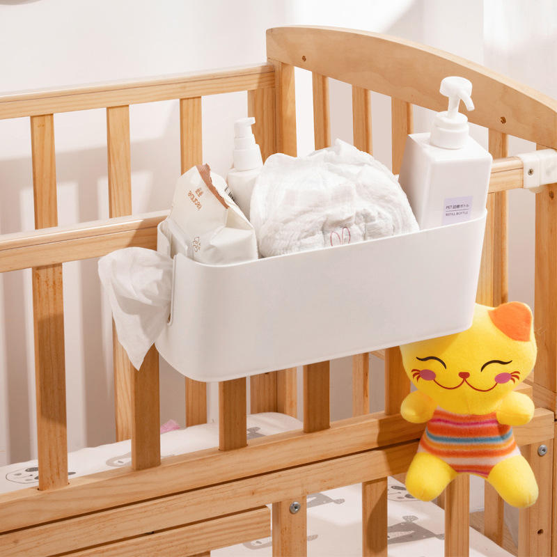 Baby crib hanging basket holding diapers and wipes in nursery
