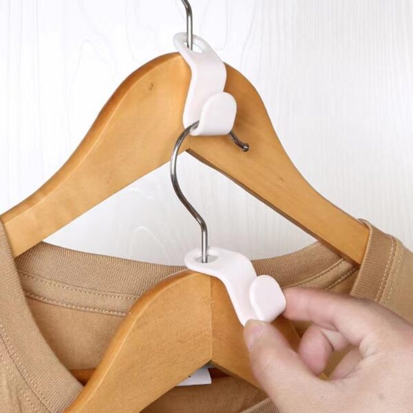 Close-up of hands installing a plastic hanger connector clip on wooden hangers