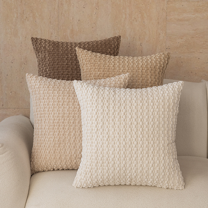 Neutral tone textured pillow covers closeup on cream sofa