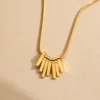 Water-resistant gold fan pendant necklace on beige background