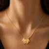 Model wearing water-resistant gold fan pendant necklace