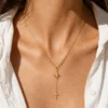Water-resistant gold star drop necklace worn on neckline
