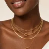 Model wearing gold layered toggle coin necklace