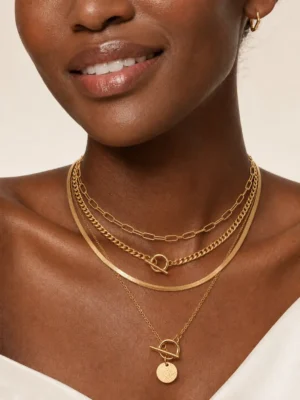 Model wearing gold layered toggle coin necklace