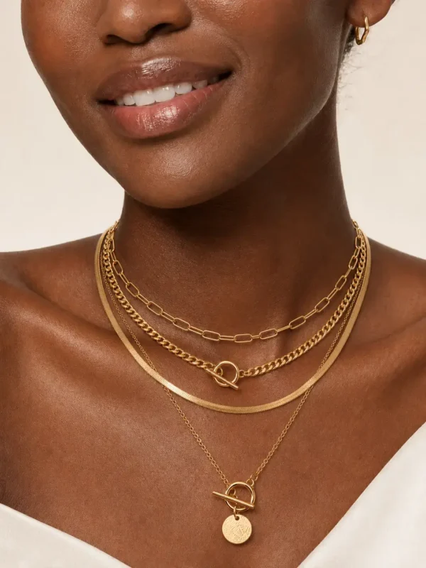 Model wearing gold layered toggle coin necklace