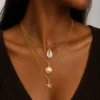 Model wearing gold layered shell starfish necklace