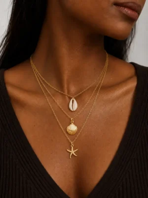 Model wearing gold layered shell starfish necklace