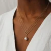 Model wearing gold geometric pearl pendant necklace