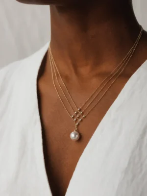 Model wearing gold geometric pearl pendant necklace