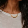 Model wearing gold geometric square bead necklace