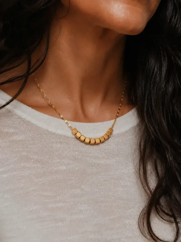 Model wearing gold geometric square bead necklace