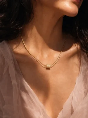 Model wearing gold layered bar chain necklace