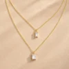 Gold layered baguette crystal necklace on beige background