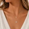 Model wearing gold layered baguette crystal necklace
