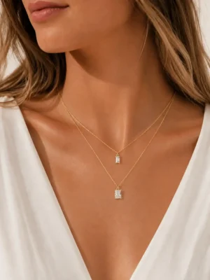 Model wearing gold layered baguette crystal necklace