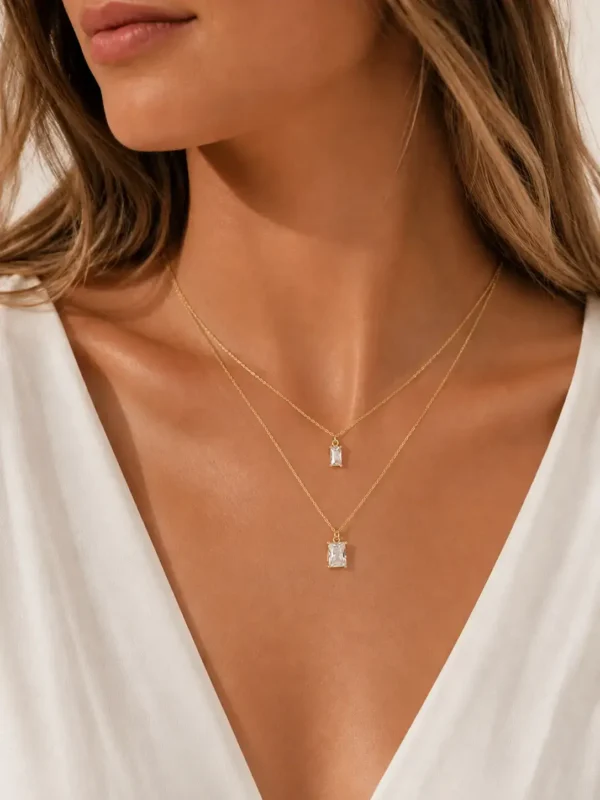 Model wearing gold layered baguette crystal necklace