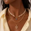 Model wearing gold layered evil eye pearl necklace