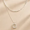 Silver layered rectangle pendant necklace set on beige background