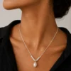 Model wearing silver-tone pearl drop necklace