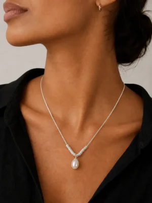Model wearing silver-tone pearl drop necklace