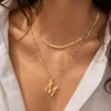 Model wearing gold initial M layered necklace