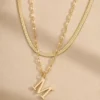 Gold initial M layered necklace close up
