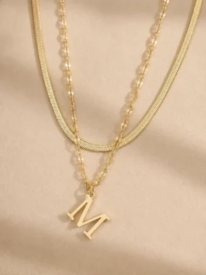 Gold initial M layered necklace close up