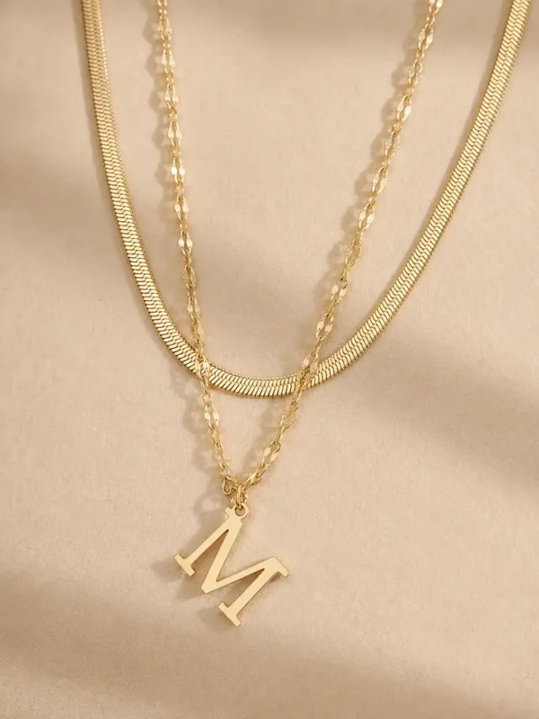 Gold initial M layered necklace close up