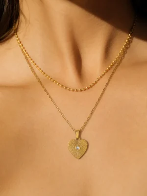 Model wearing 18K gold-plated heart layered necklace