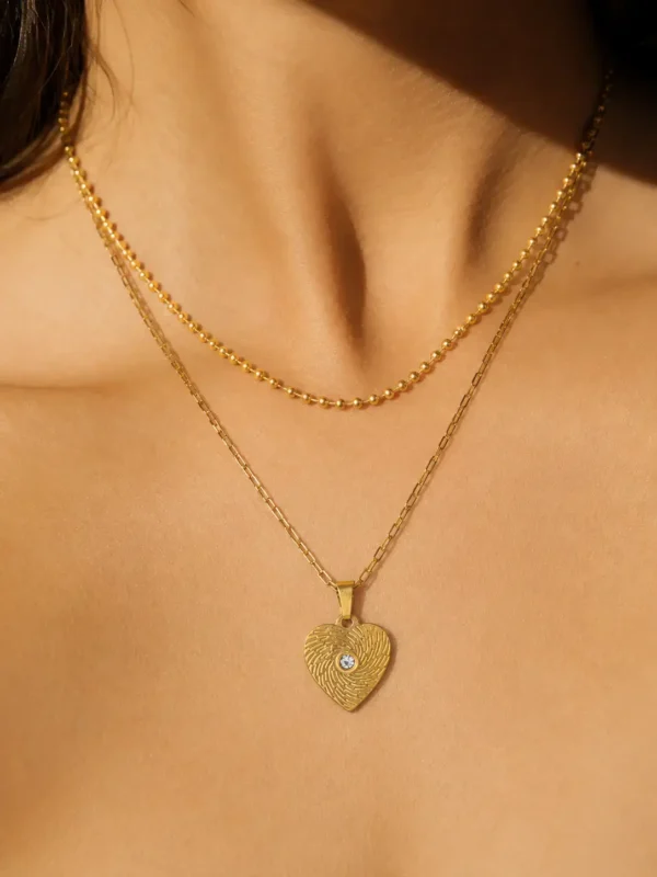 Model wearing 18K gold-plated heart layered necklace