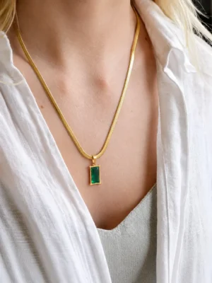 Model wearing gold green stone pendant necklace